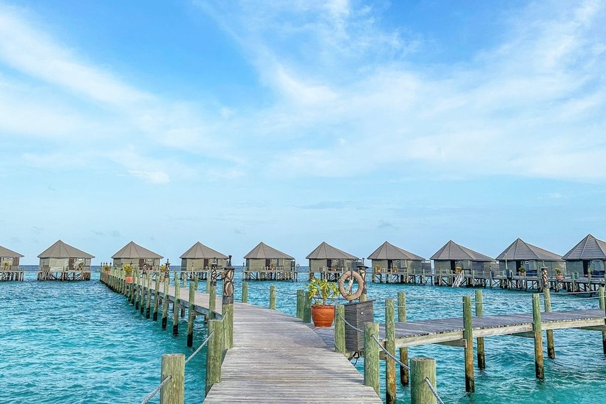 Foto colorida de cabanas e corredor, construídos dentro do mar 