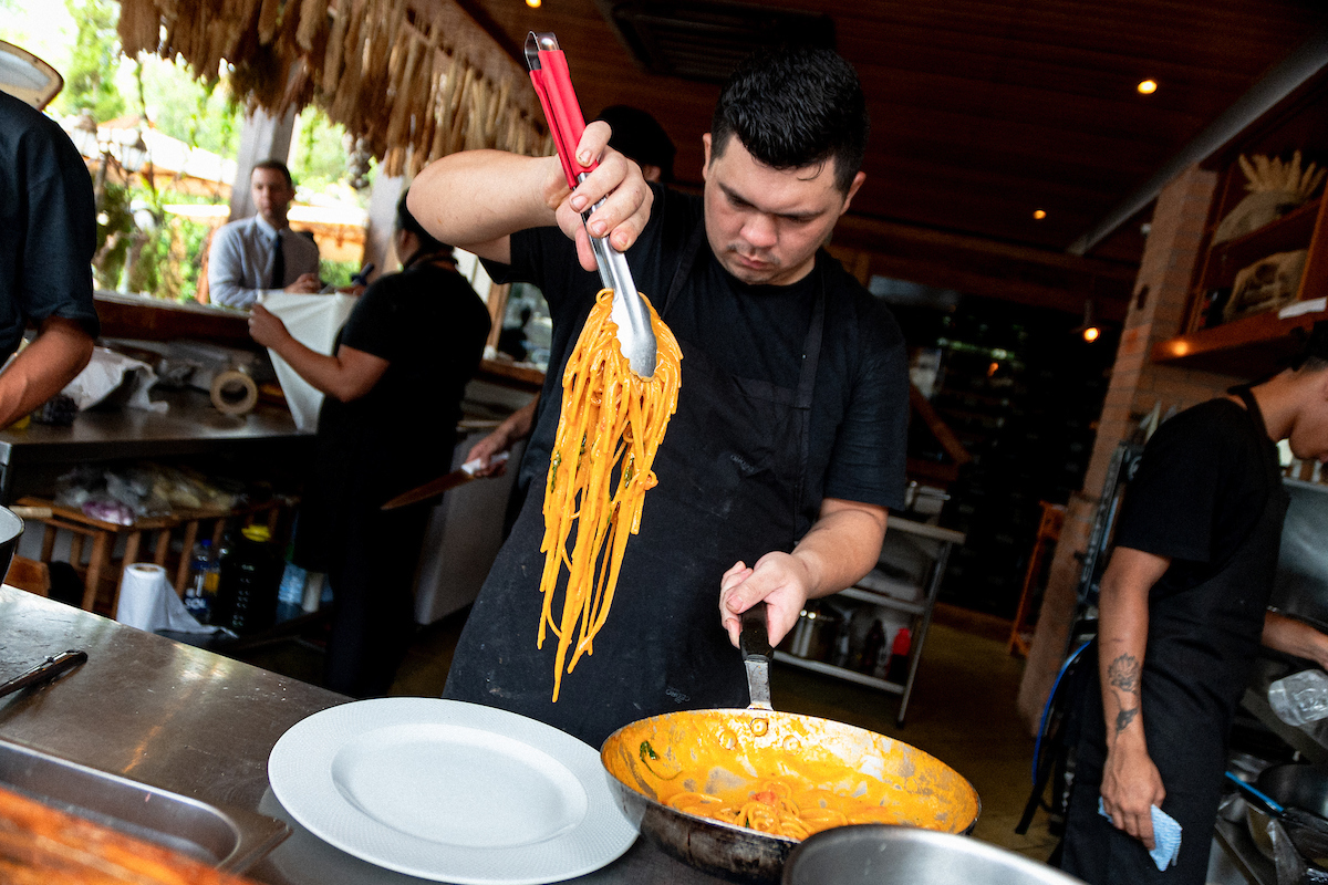 Colaborador prepara a tradicional carbonara 