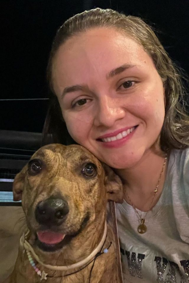 Foto colorida de uma mulher com cachorro - Metrópoles