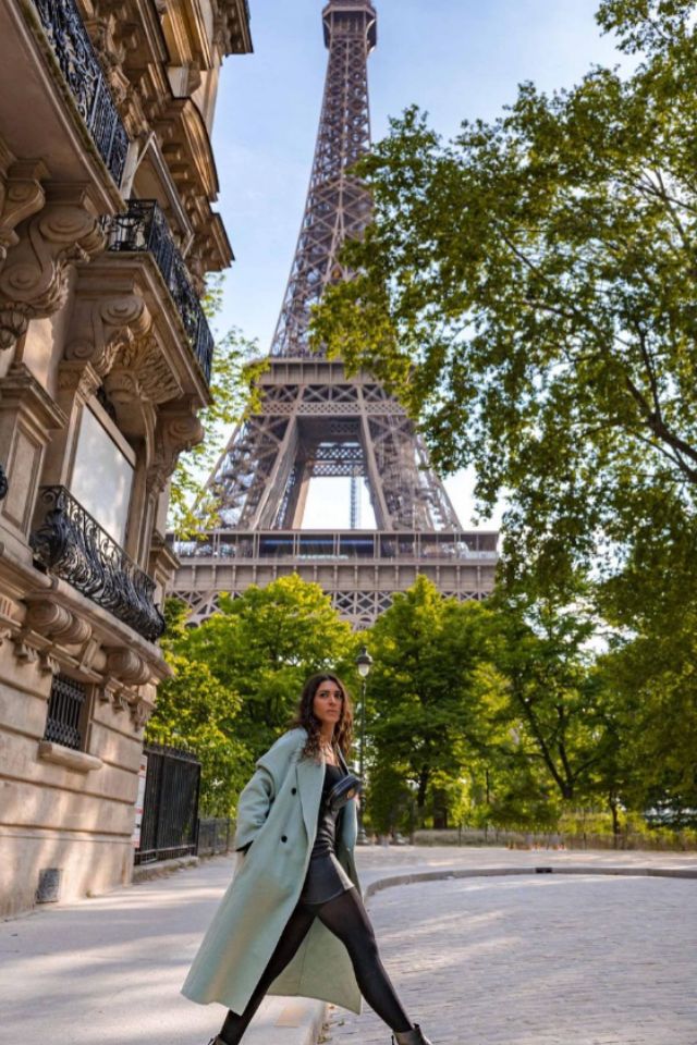 Foto colorida de uma mulher em frente a Torre Eiffel - Metrópoles