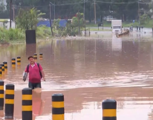 Imagem colorida de rua completamente alagada, com água suja da chuva - Metrópoles