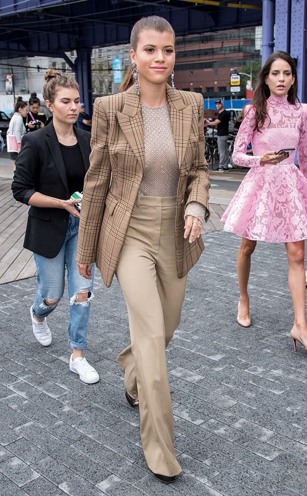 Na imagem com cor, Sofia Richie, mulher branca com cabelo loiro preso, usa um look monocromático enquanto caminha por rua - Metrópoles