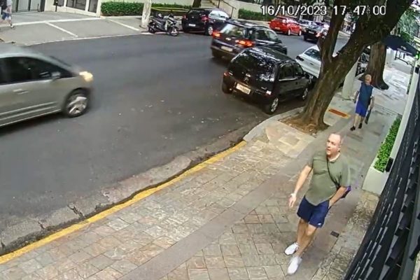 Imagem colorida mostra homem branco caminhando em uma calçada de rua residencial - Metrópoles