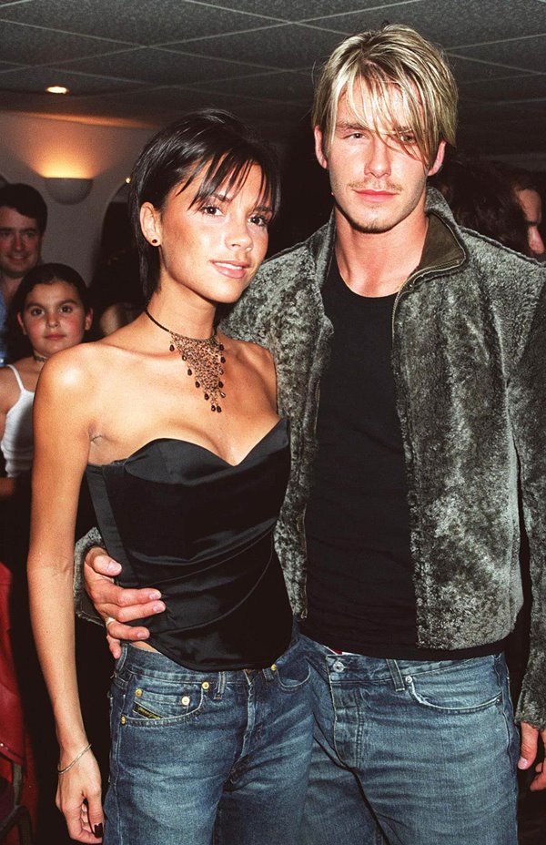 David Beckham e Victoria Beckham abraçados, usam preto e jeans - Metrópoles