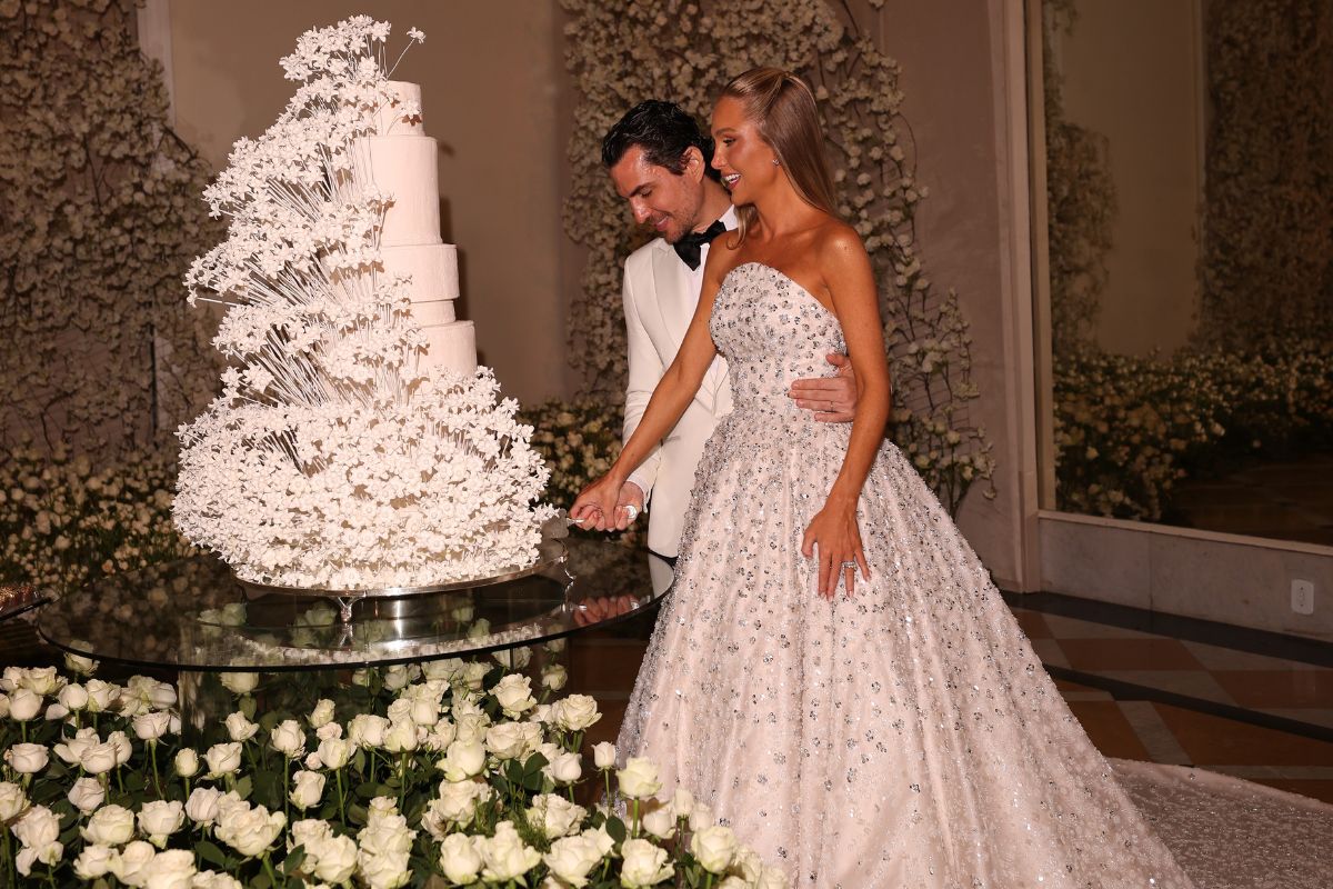 Francisco Garcia e Paula Aziz cortando um bolo de casamento