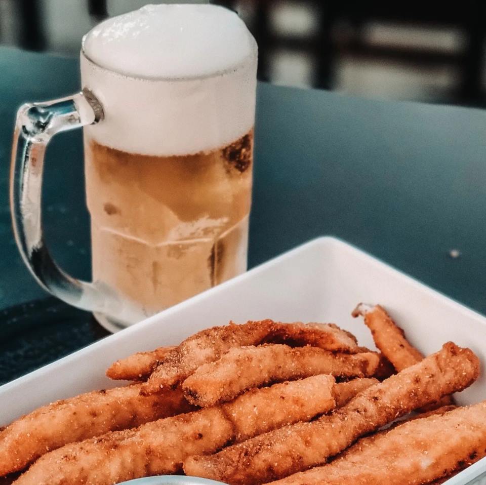 Foto colorida de uma cerveja com isca de peixe - Metrópoles