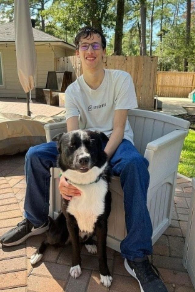 Foto colorida de um jovem com cachorro - Metrópoles