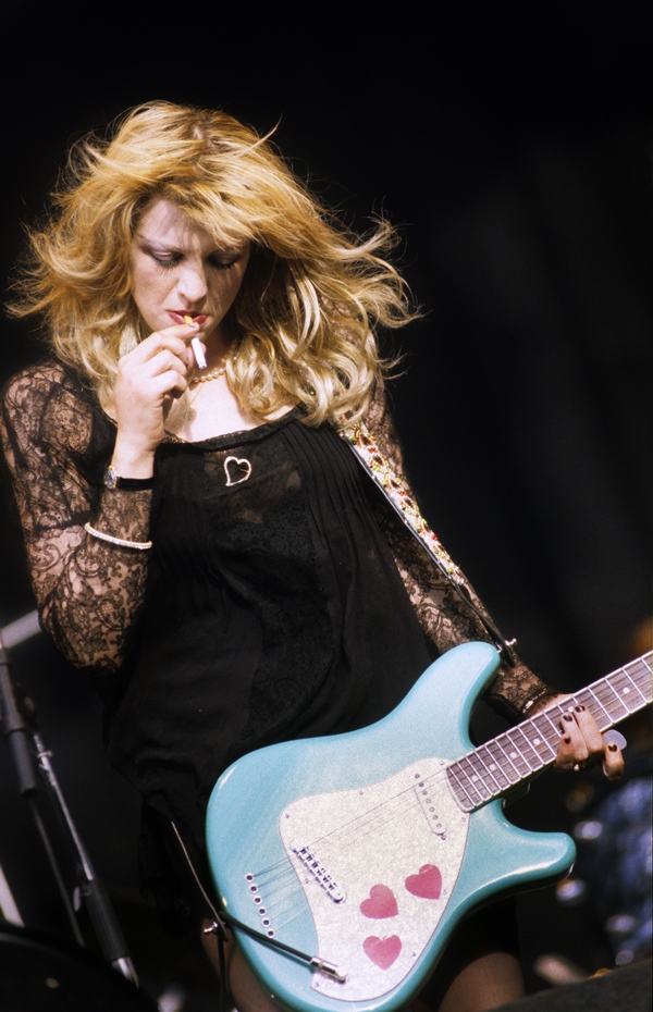 Cantora Courtney Love fumando e segurando guitarra - Metrópoles