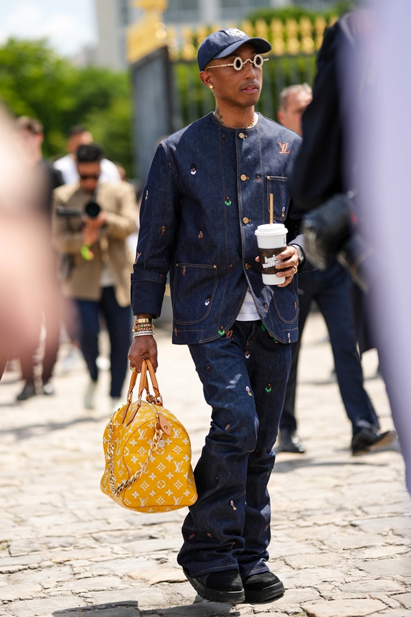 Na imagem com cor, Pharrell Williams andando durante o Paris Fashion Week com bolsa feita de pele de crocodilo - Metrópoles