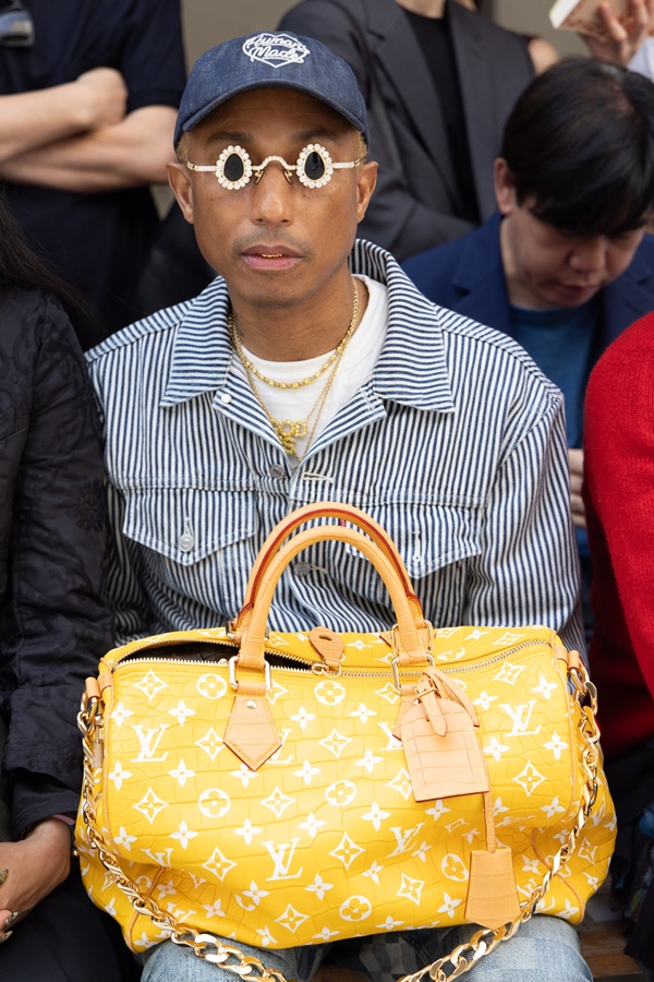 Na imagem com cor, Pharrell Williams andando durante o Paris Fashion Week com bolsa feita de pele de crocodilo - Metrópoles