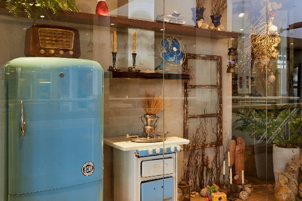 Foto colorida de uma vitrine com geladeira e fogão antigos na cor azul - Metrópoles 