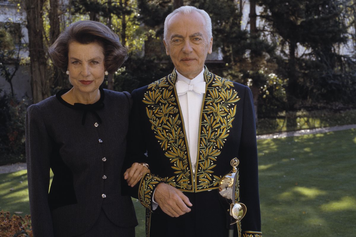 Foto colorida de mulher idosa, com cabelo curto e roupa preta, ao lado de home idoso, com roupa de autoridade - Metrópoles