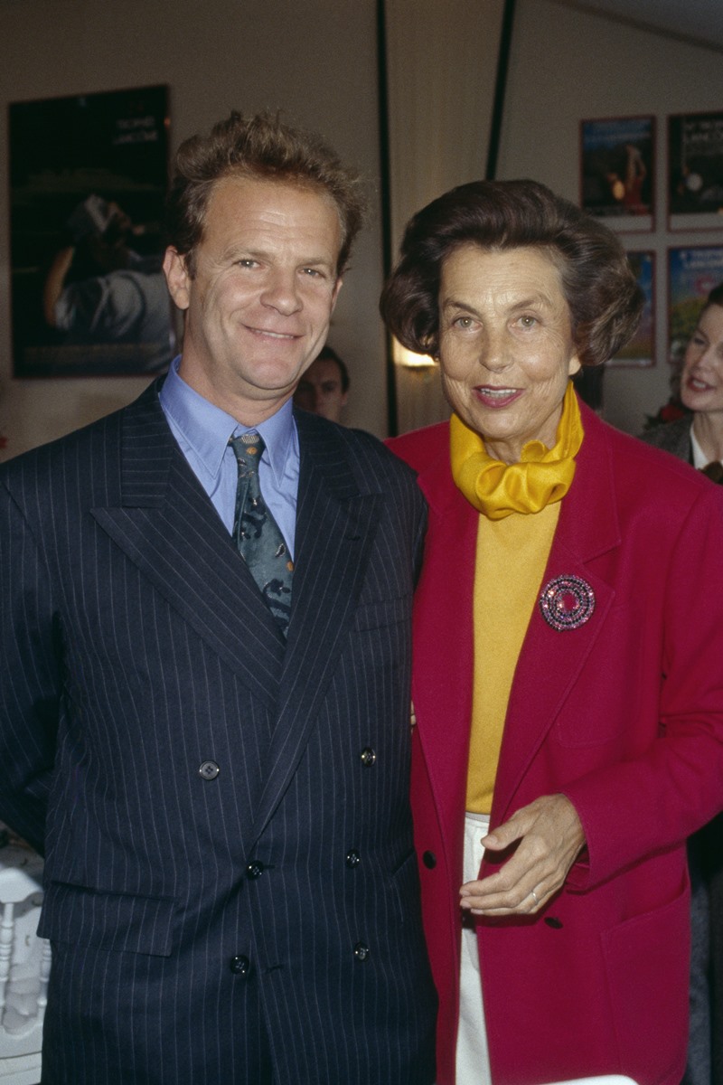 Foto colorida de homem, com terno e cabelo castanho, ao lado de mulher idosa, com blusa amarela e blazer vermelho - Metrópoles