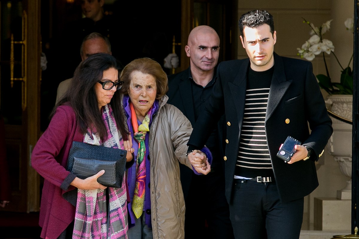 Foto colorida de uma mulher ajudando outra, mais idosa a caminhar. Um homem jovem, com roupas pretas, também auxilia a idosa - Metrópoles