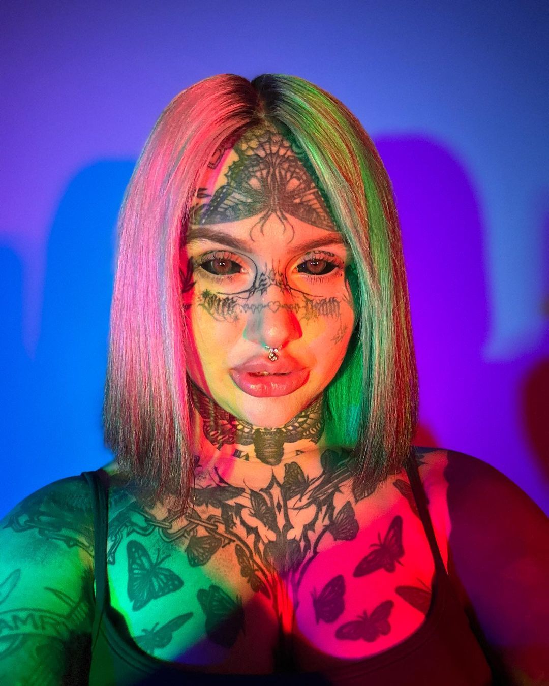 mulher com cabelo colorido e tatuagens no rosto