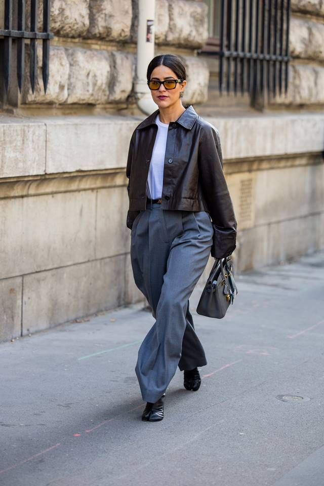 Tabi no street style. Mulher usa o calçado com camiseta branca, jaqueta preta e calça azul - Metrópoles