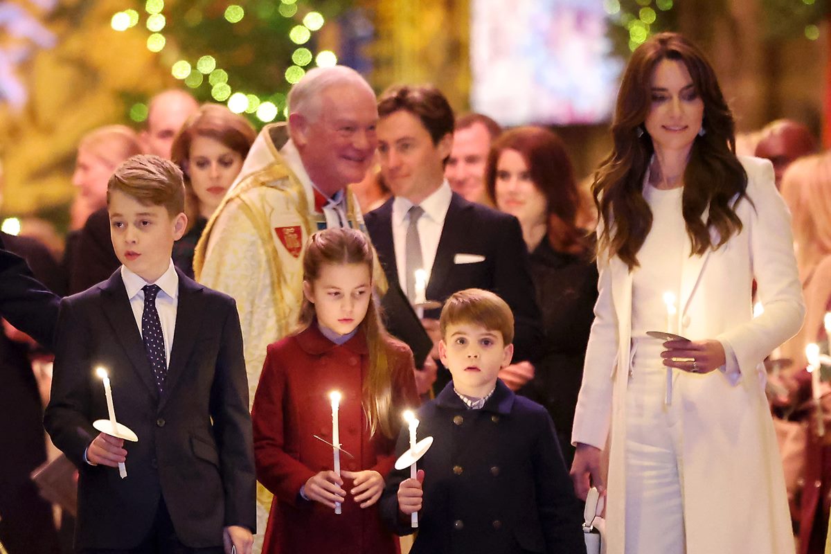 Foto de crianças, padre e mulher com roupa branca. As crianças seguram velas - Metrópoles