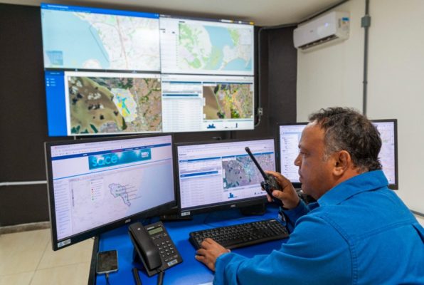 Fotografia colorida mostrando homem operando computadores em sala de operação-Metrópoles