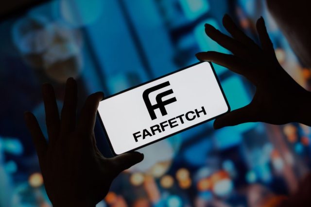 Na imagem com cor, a logo da Farfetch em celular - Metrópoles