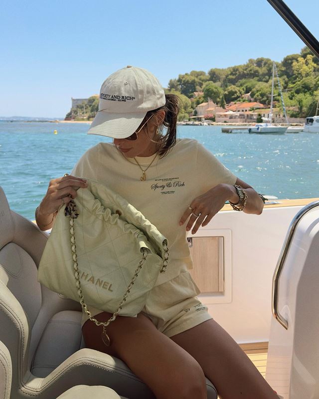 Em barco no mar, mulher usa boné e camiseta - Metrópoles