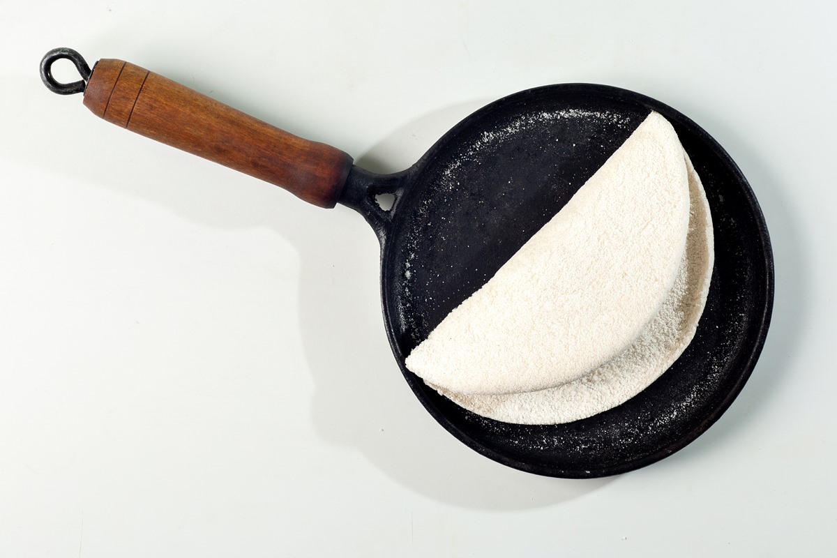 Foto colorida de tapioca pronta em uma frigideira preta - Metrópoles