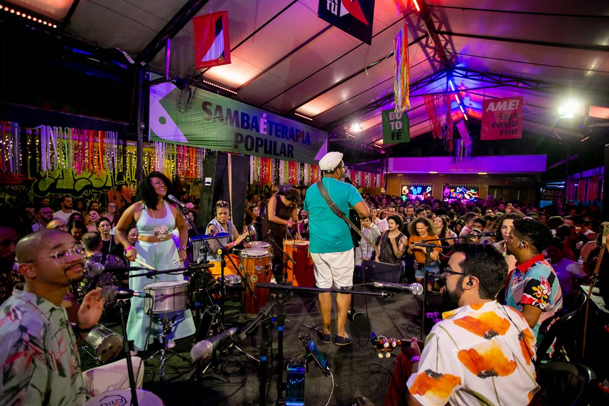 foto colorida de pessoas ao redor de palco - metrópoles