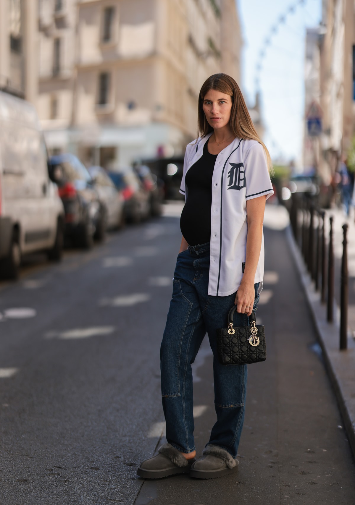 mulher pantufas camisa de baseball calça jeans e bolsa preta - metrópoles