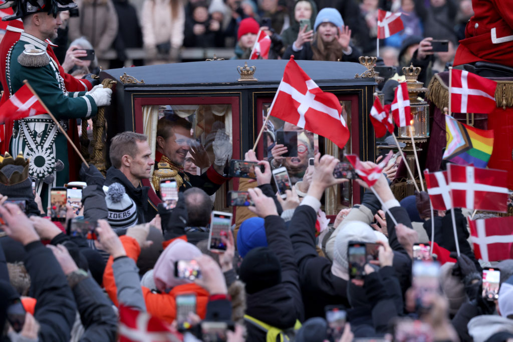 O rei dinamarquês Frederik X e sua esposa, a rainha Mary da Dinamarca, acenam para a multidão ao deixarem o Palácio de Christiansborg em uma carruagem