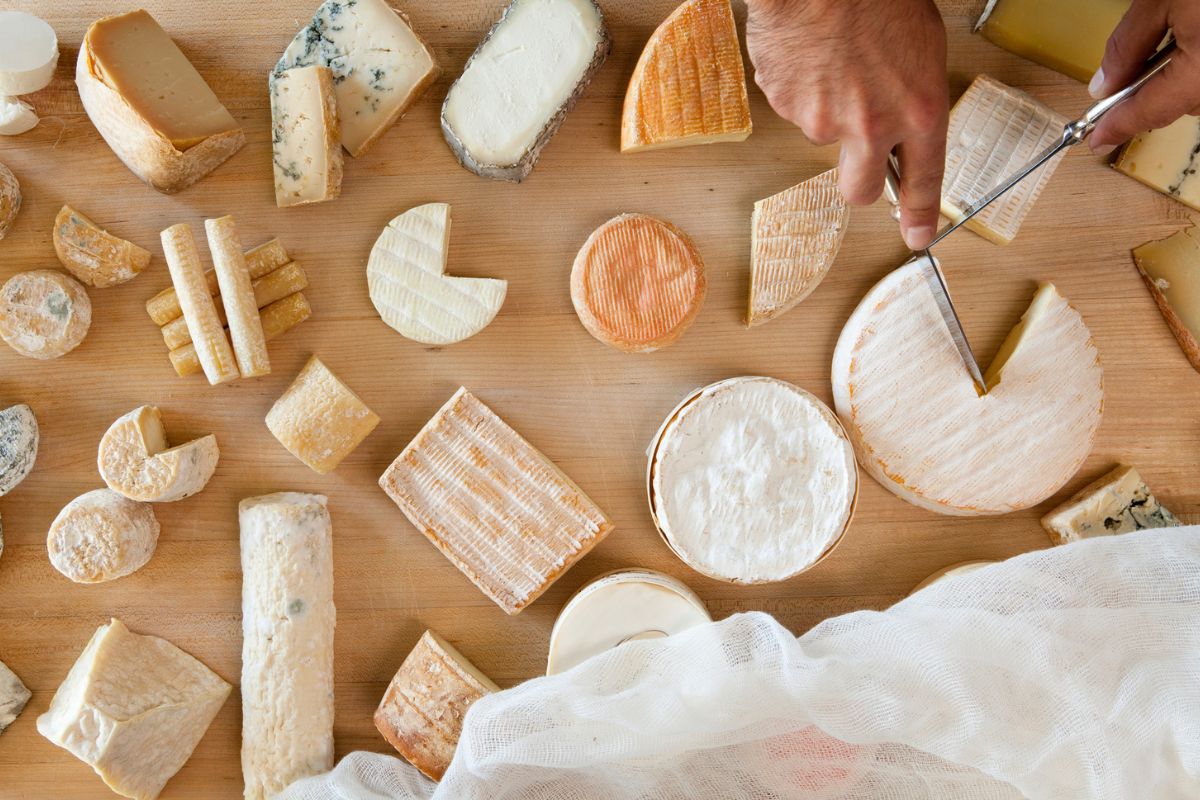 vários tipos de queijo em uma mesa de madeira