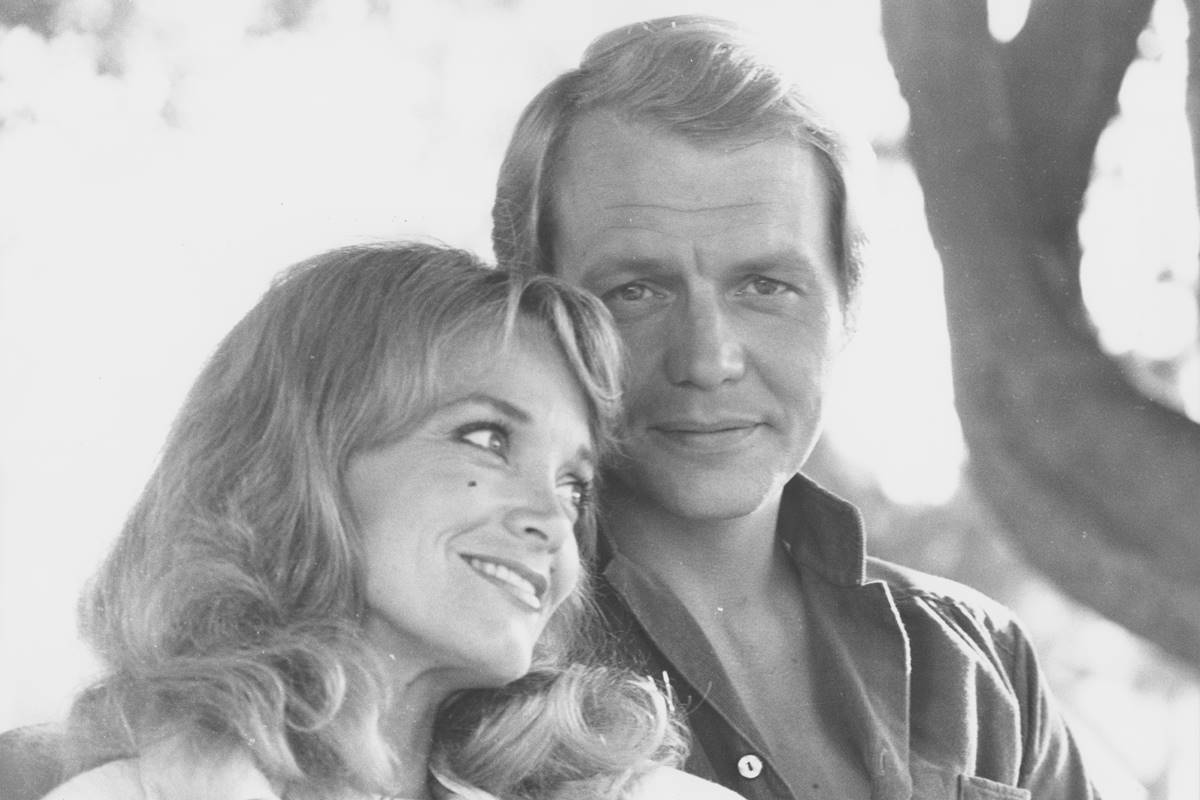 David Soul e Lynne Marta em foto preto e branco, abraçados e sorrindo - Metrópoles