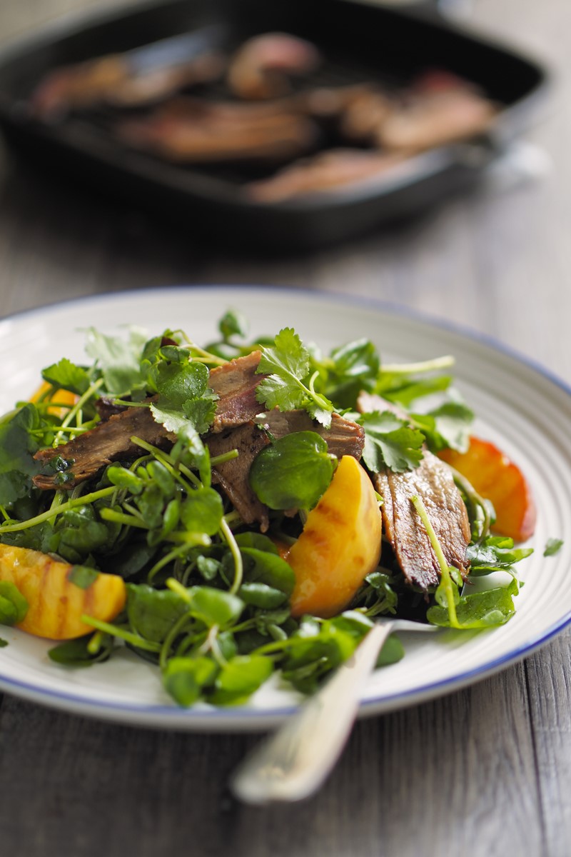 Foto de prato branco com carne, legumes e verduras. Dentro do objeto tem uma colher - Metrópoles