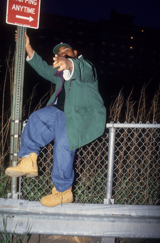 Raekwon apoiado em placa com suas Timberlands.