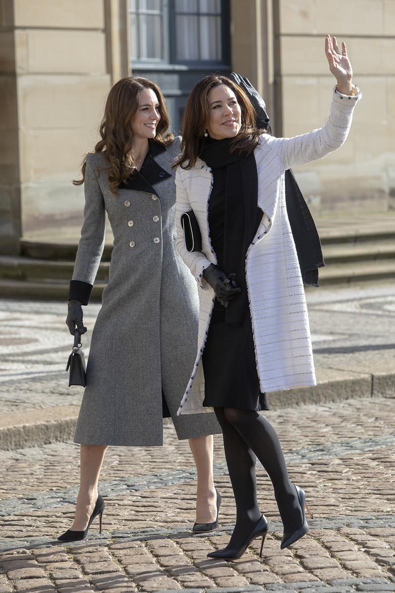 Foto colorida de mulheres com cabelo castanho. Elas estão acenando e caminhando. Também usam roupas de frio - Metrópoles