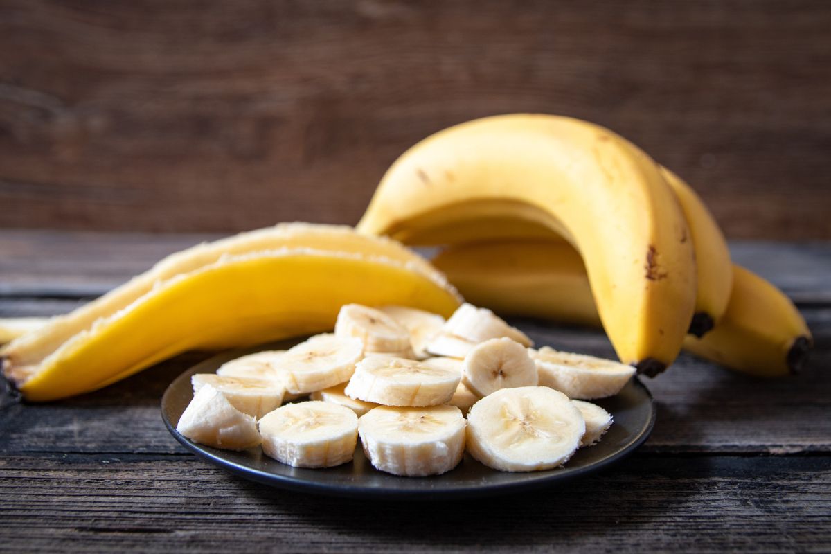 duas bananas inteiras e uma cortada em rodelas no prato