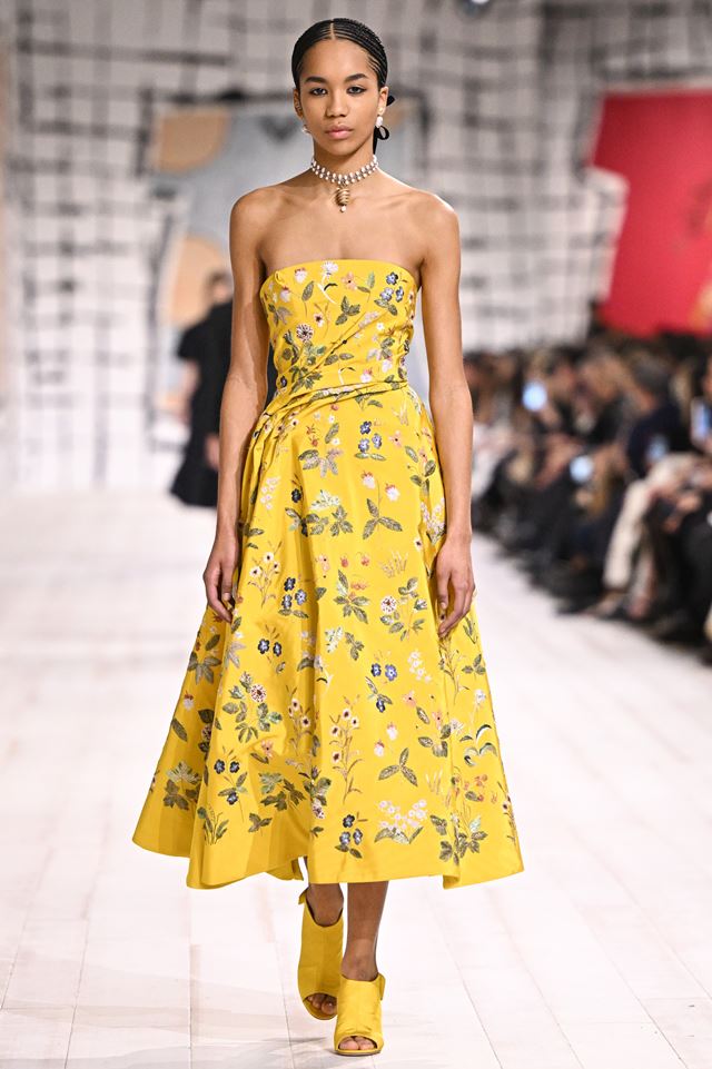 Na passarela, modelo usa vestido amarelo, sem alças e com estampa floral - Metrópoles