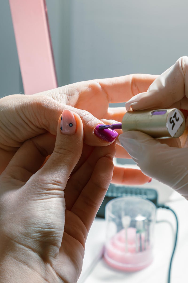 Mãos pintando as unhas de mãos de outra pessoa - Metrópoles