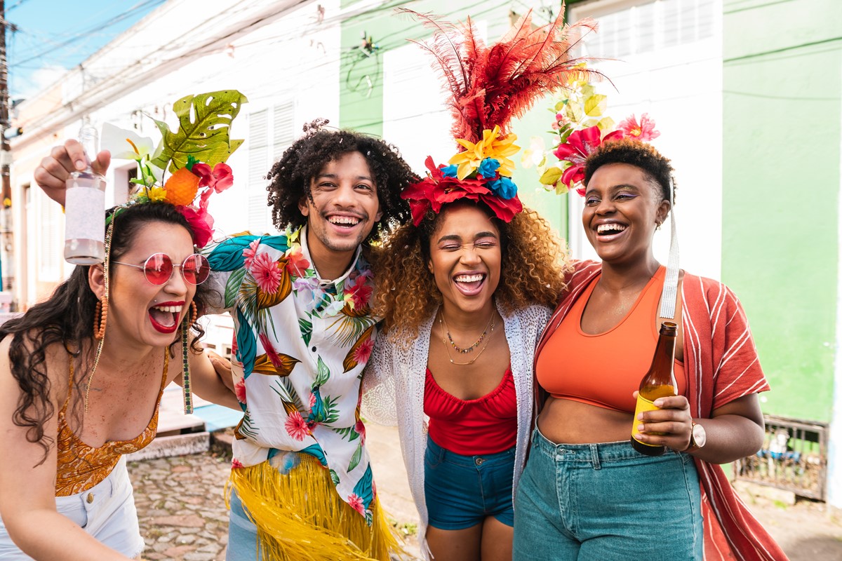 Grupo de quatro pessoas em adereços de carnaval - metrópoles