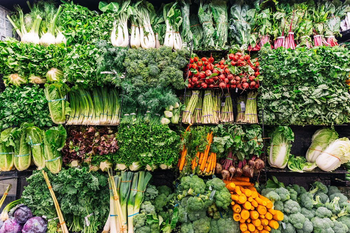 Prateleira de supermercado com folhas e legumes expostos