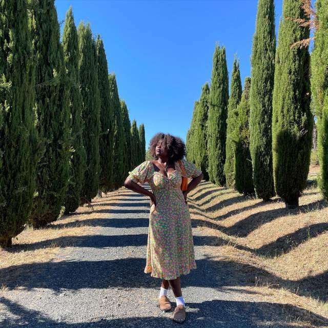 Na imagem com cor, uma mulher posando para foto com um vestido fresco floral para o verão - Metrópoles