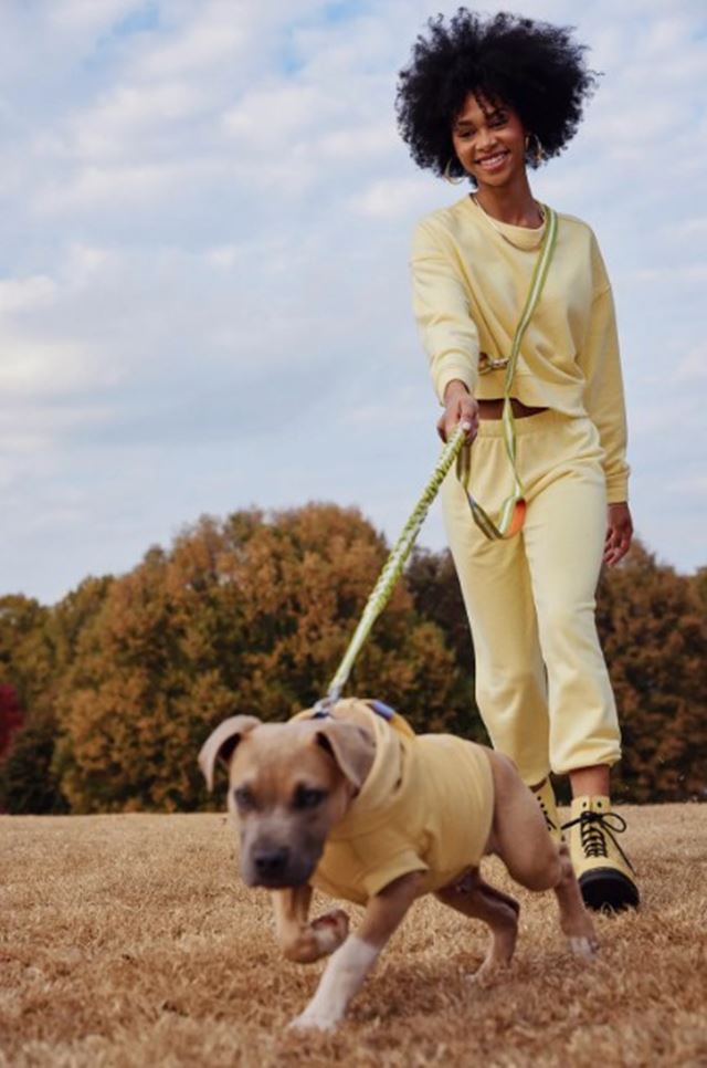 Com look amarelo de moletom, mulher passeia com cachorro em campanha de moda - Metrópoles