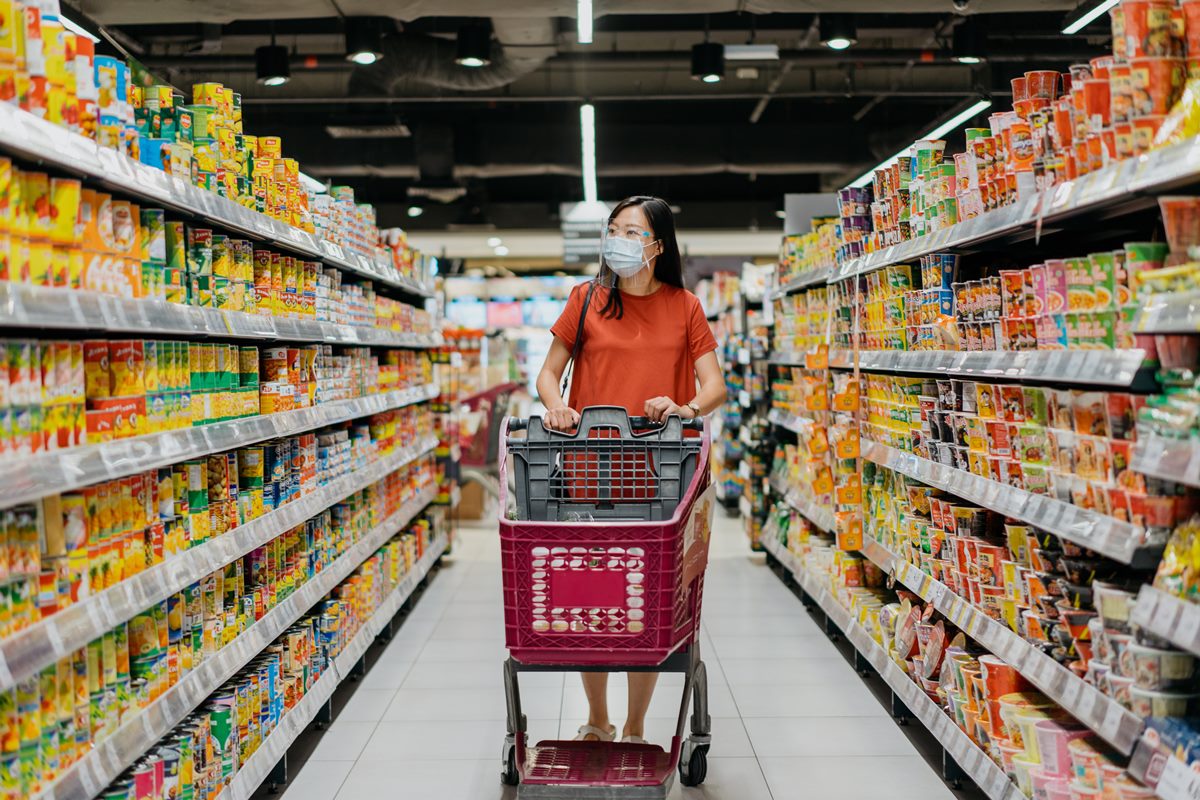 Mulher no corredor de alimentos processados