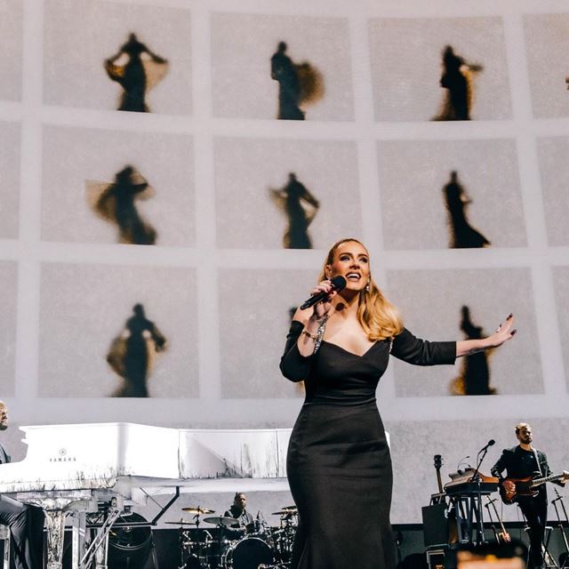 Na imagem com cor, a cantora Adele durante apresentação em Las Vegas - Metrópoles