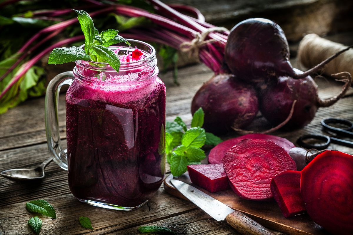 copo com suco de beterraba e beterrabas atrás