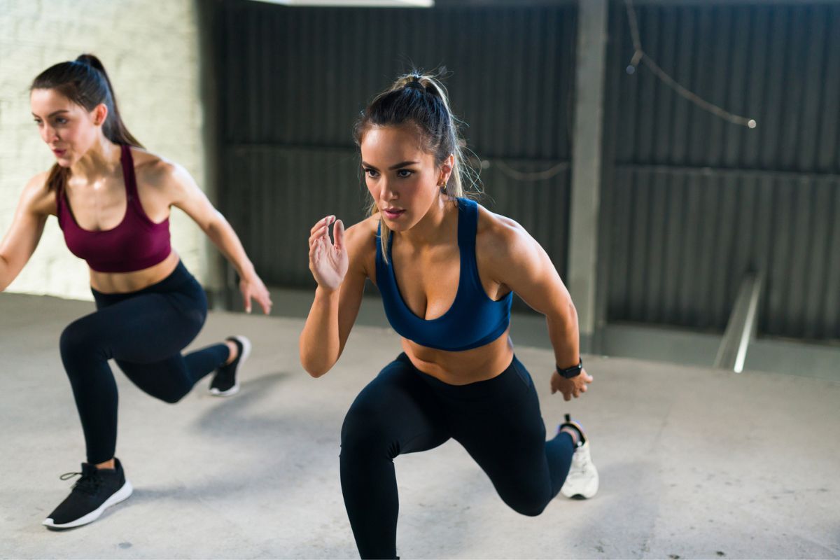 duas mulheres fazendo afundo com o peso do corpo