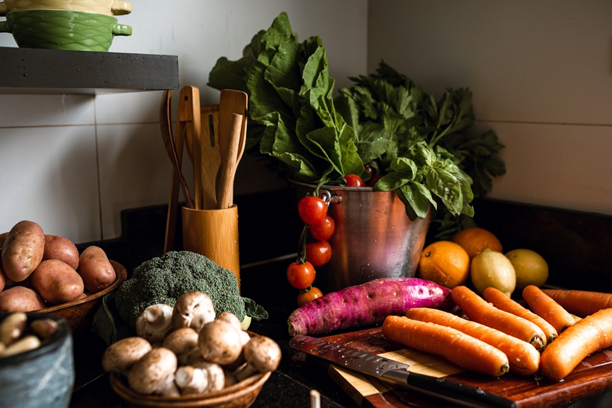 Mesa com diversos legumes, folhas e vegetais 