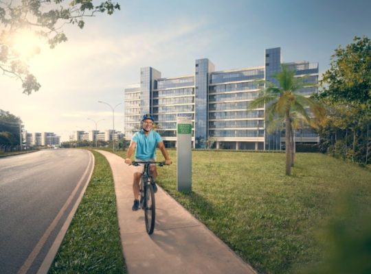 Fotografia colorida mostrando homem andando de bicicleta perto de prédio-Metrópoles