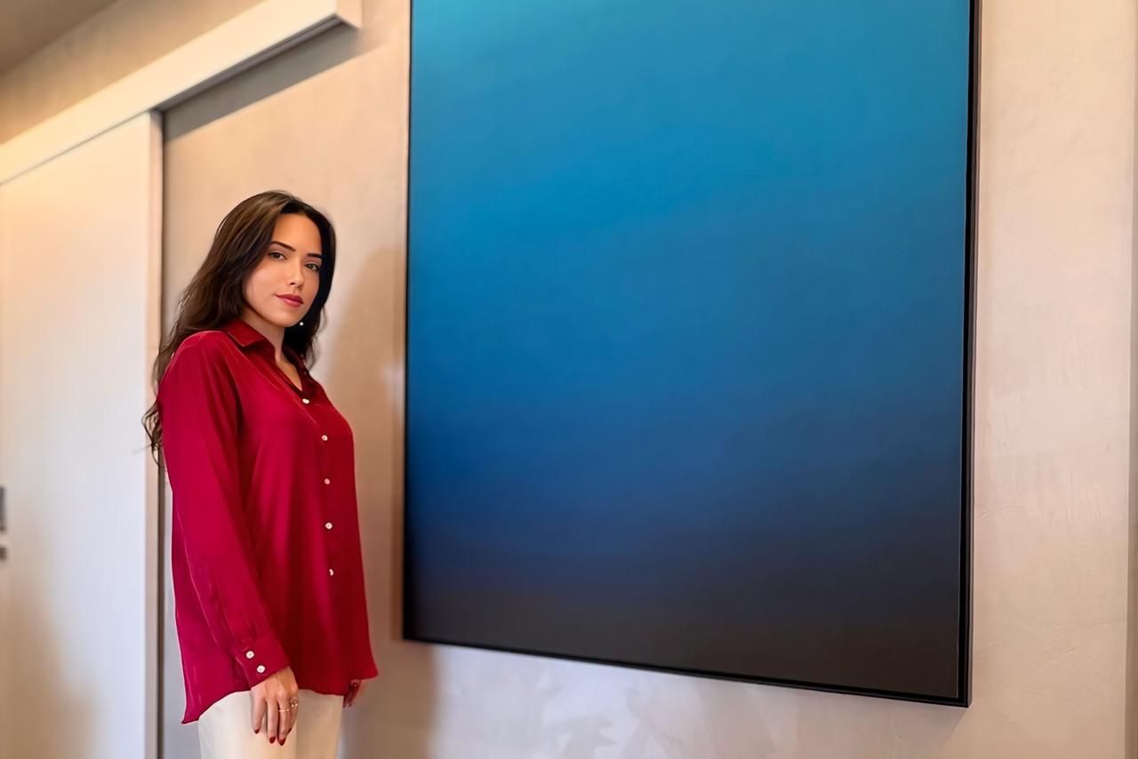 Mulher de blusa vermelha em frente a um quadro - Metrópoles