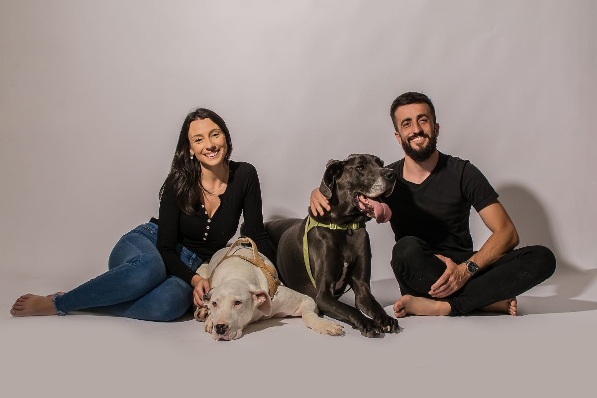 Foto colorida de um casal e dois cachorros - Metrópoles