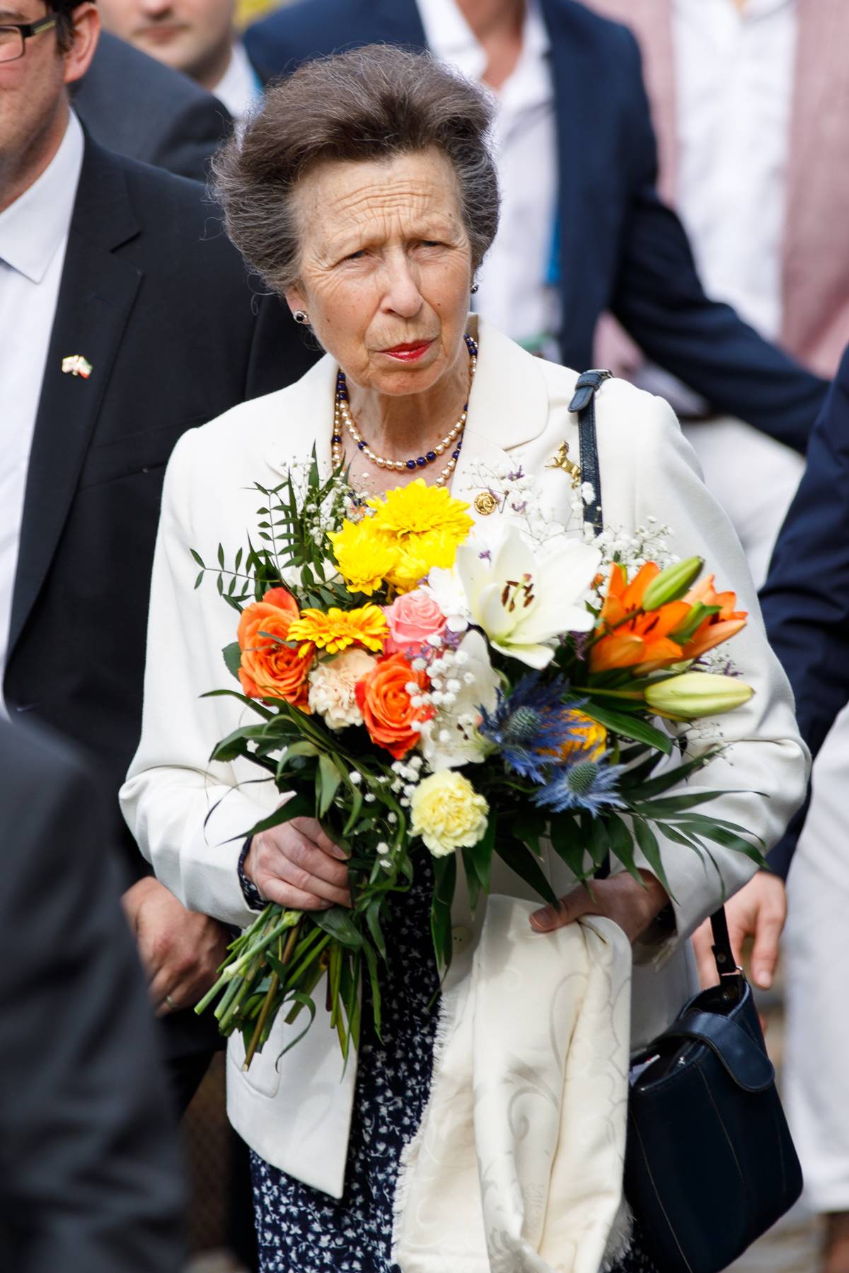 Foto de mulher idosa segurando buquê de flores - Metrópoles