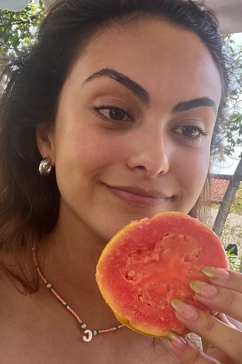 Foto colorida de mulher segurando um pedaço de goiaba - Metrópoles